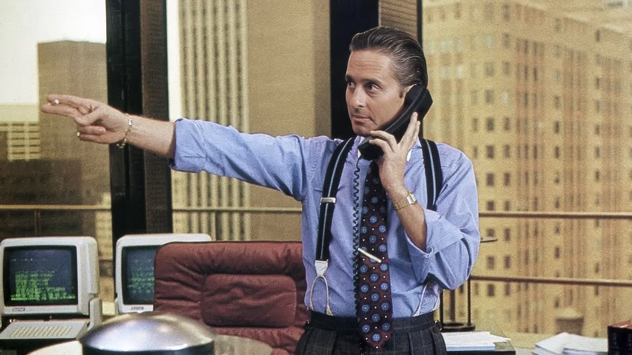 Quando Wall Street uscì nel dicembre del 1987, l’America era ancora scossa dal Black Monday: il 19 ottobre, il Dow Jones Industrial Average crollò di 508 punti in una sola seduta, segnando un -22,6% e registrando la peggior perdita giornaliera nella storia della Borsa USA. Il tempismo fu involontariamente perfetto: il film di Oliver Stone arrivò come una radiografia drammatica di un sistema finanziario ipertrofico, cresciuto all’ombra della deregolamentazione reaganiana, e capace di auto-alimentare bolle speculative scollegate dall’economia reale.